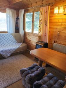 Zimmer mit einem Bett und einem Tisch in einer Hütte in der Unterkunft Agroturystyka 3 chaty red black I nanna in Młynary