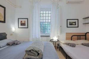 sypialnia z 2 łóżkami i oknem w obiekcie B&B Cristina Garden w Pizie