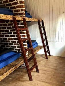 two wooden bunk beds sitting next to a brick wall at Quiver Dive Team Perhentian Dorm in Perhentian Island