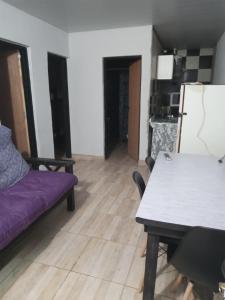 a living room with a purple couch and a table at alquiler por día en general Acha in General Acha