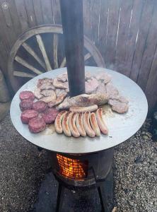 a grill with sausage and hamburgers on it at Aughnahoy Staycations Portglenone in Portglenone