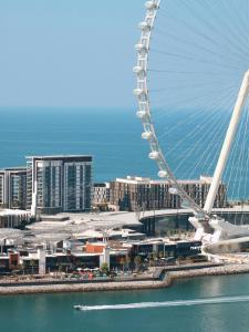 una grande ruota panoramica di fronte a una città di Happy ACADEMIA JBR a Dubai