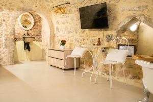 レティムノ・タウンにあるCasa Panstelの白い椅子、テーブル、シンクが備わる客室です。
