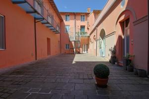 un callejón con edificios naranjas y una planta en una olla en Cristina e Elena Suite, en Pisa