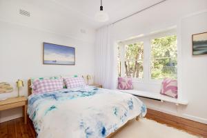 une chambre blanche avec un lit et une fenêtre dans l'établissement Emerald Cottage in the Blue Mountains, à Faulconbridge