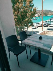 尼基亚娜Villa Don Kostangelo的阳台配有桌椅,享有停车场的景致
