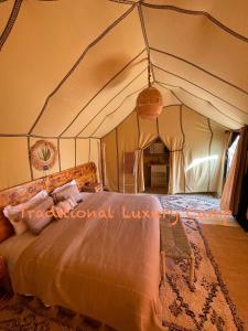 a bedroom with a bed in a tent at Berber Experience Camp in Hassilabied