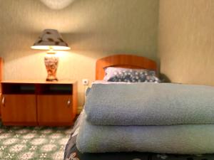 Dormitorio con cama y mesita de noche con lámpara en Bargi Sabz en Khujand