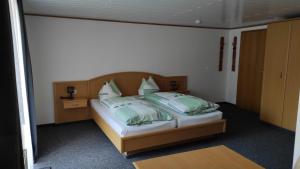 a bedroom with a bed with green and white pillows at Gasthof Zur Goldenen Sonne in Remptendorf