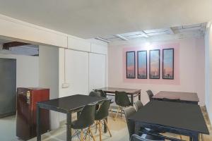 um quarto com duas mesas e cadeiras e janelas em Collection O 83129 Hotel Galaxy Hospitality em Kharadi