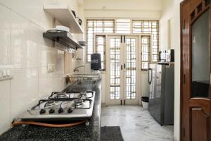 a kitchen with a stove top oven in a kitchen at Aishwarya Mystic Apartotel in Bangalore
