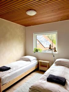 a bedroom with two beds and a window at Stoksholmene13 in Svebølle