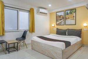 een slaapkamer met een bed, een tafel en een stoel bij Collection O 83129 Hotel Galaxy Hospitality in Kharadi