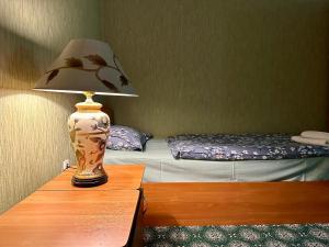 a lamp sitting on a table next to a bed at Bargi Sabz in Khujand