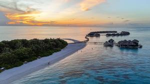 een luchtzicht op een resort in de oceaan bij zonsondergang bij Coco Bodu Hithi in North Male Atoll