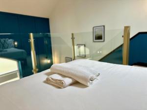 a white towel sitting on top of a bed at The Gallery in Blandford Forum
