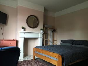 a bedroom with a bed and a mirror on the wall at The Snug in Fordingbridge