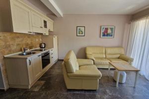 a kitchen with two chairs and a table and a sink at Kazanegra Exclusive Apartments in Sveti Stefan