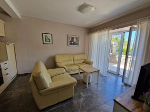 a living room with two chairs and a tv at Kazanegra Exclusive Apartments in Sveti Stefan