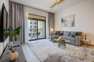 sala de estar con sofá y mesa en Trophy - Countryside Bliss Suites en Dubái