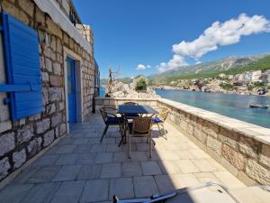 een patio met een tafel en stoelen en uitzicht op het water bij Kazanegra Exclusive Apartments in Sveti Stefan