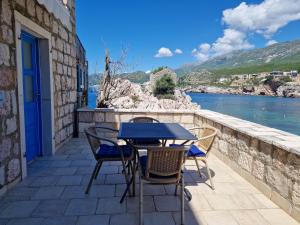 einen Tisch und Stühle auf einer Terrasse mit Blick auf das Wasser in der Unterkunft Kazanegra Exclusive Apartments in Sveti Stefan