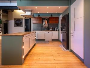 a kitchen with white cabinets and a wooden floor at Loft Eiffel unique et atypique, au coeur de ville in Béziers +17 photos