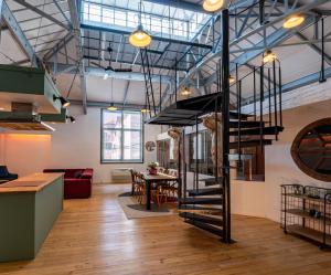 a loft with a spiral staircase in a room at Loft Eiffel unique et atypique, au coeur de ville in Béziers