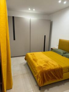 um quarto com uma cama com um cobertor amarelo em Appartamento Umberto em Piacenza