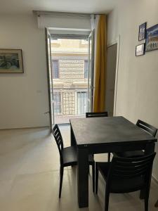 uma mesa preta e cadeiras num quarto com uma janela em Appartamento Umberto em Piacenza