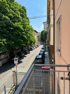 uma varanda de um edifício com carros estacionados numa rua em Appartamento Umberto em Piacenza