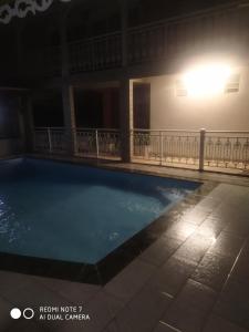 a swimming pool in a building at night at Charmant haut de villa 8 minutes de l'Hôpital de la Meynard in Saint-Joseph