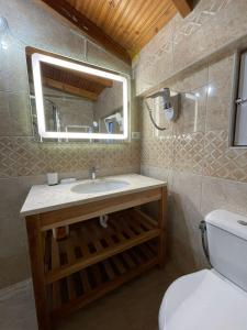 y baño con lavabo, aseo y espejo. en Hotel Kolagji, en Himare