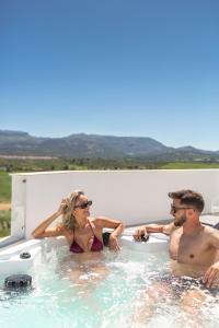 un hombre y una mujer sentados en una bañera en Apartamentos Martalia - La Casa del Cedro Luxury, en Ronda