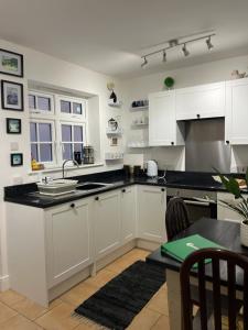 a kitchen with white cabinets and a black counter top at THE ANCHOR in Hastings