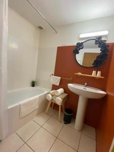 a bathroom with a sink and a tub and a mirror at Os-thel, Chambres à louer in Tautavel