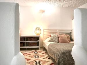 Habitación blanca con cama y alfombra en Casa Saudade - FERRAGUDO CENTRE, en Ferragudo