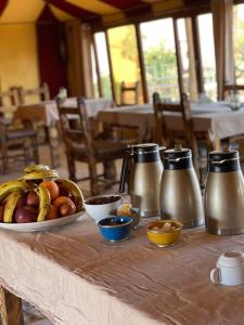 un tavolo ricoperto da un piatto di frutta e brocche di Berber Experience Camp ad Adrouine