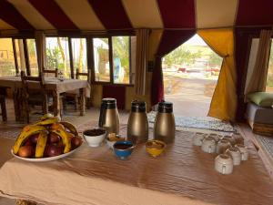 a table in a tent with a bowl of fruit at Berber Experience Camp in Hassilabied