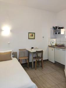 Zimmer mit einem Bett und einem Tisch sowie einer Küche in der Unterkunft Argiro Studios in Skala Rachoniou