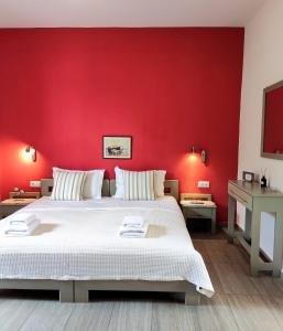 スカラ・ラクニオウにあるArgiro Studiosの赤い壁のベッドルーム(ベッド付)