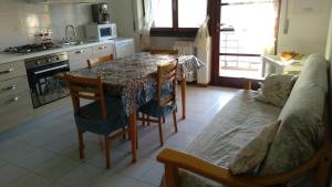 uma cozinha com uma mesa e cadeiras e um sofá em Le Palme Apartment em Gargallo