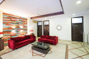 a living room with two red couches and a table at Collection O Hotel Radiant Inn in Gurgaon