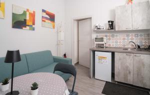 ein Wohnzimmer mit einem Sofa und einem Tisch sowie eine Küche in der Unterkunft Casa Vacanze Alma B&B grazioso appartamento sul lungomare di Pozzuoli a 300mt dal centro e dal Rione Terra by Movery in Pozzuoli