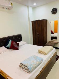 a bedroom with a bed with towels on it at Manjushree Guest House in Ujjain