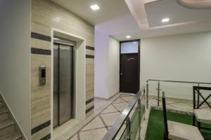 a hallway with a black door and a staircase at Collection O Hotel Radiant Inn in Gurgaon