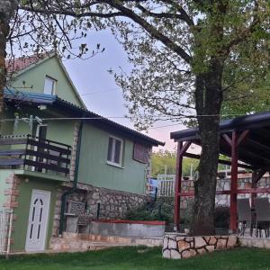 a green house with a tree in front of it at Green House Izvor Vrilo in Tomislavgrad