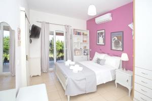 a bedroom with a white bed and purple walls at Eleni's House by Corfuescapes in Corfu