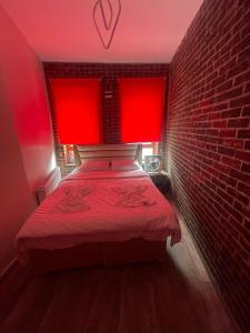 a red room with a bed with a brick wall at GRAND BELLA VİSTA Hostel in Istanbul