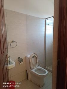 a bathroom with a toilet and a sink at Elegant furnished rooms with swimming pool in Nyali in Mombasa